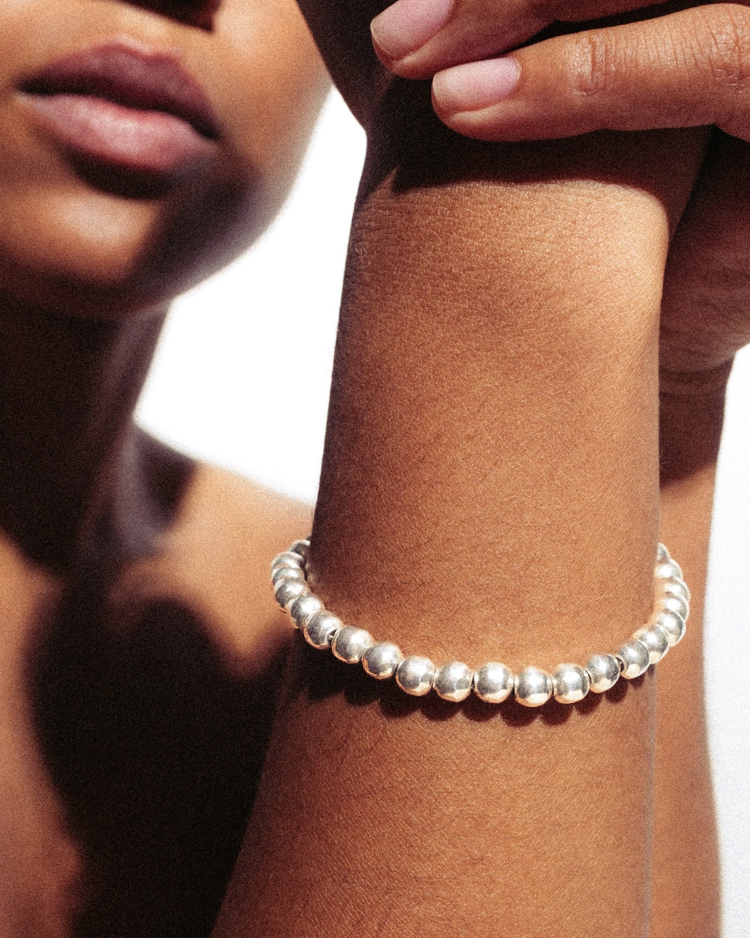 Silberarmband aus gleichmäßig runden Kugeln mit T-Verschluss. Glänzende Oberfläche, schlichtes, modernes Design.