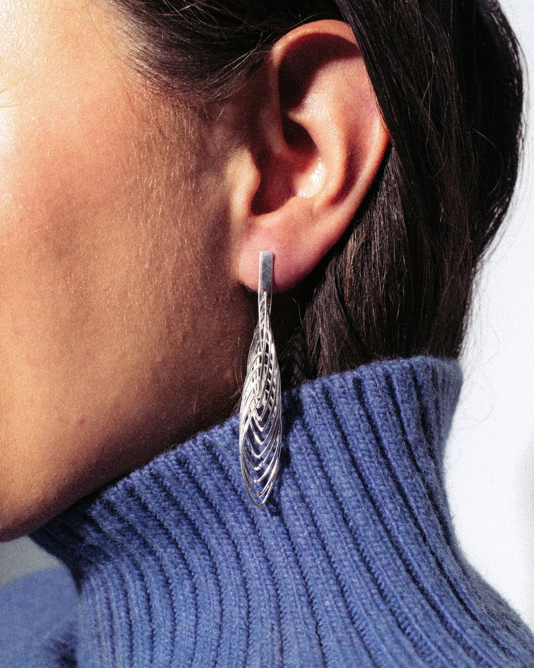 Lange, skulpturale Ohrstecker aus 925er Silber mit offener, gefiederter Struktur. Leicht wirkendes Design mit Steckverschluss.